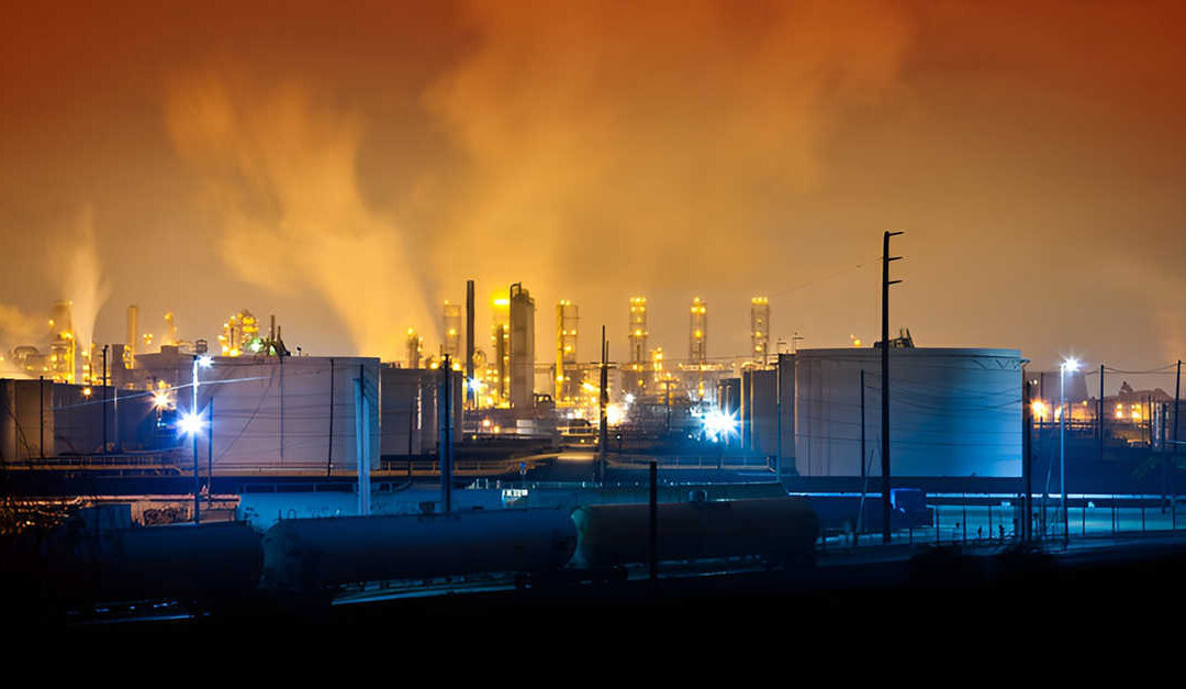 oil refinery facility at night with storage tanks